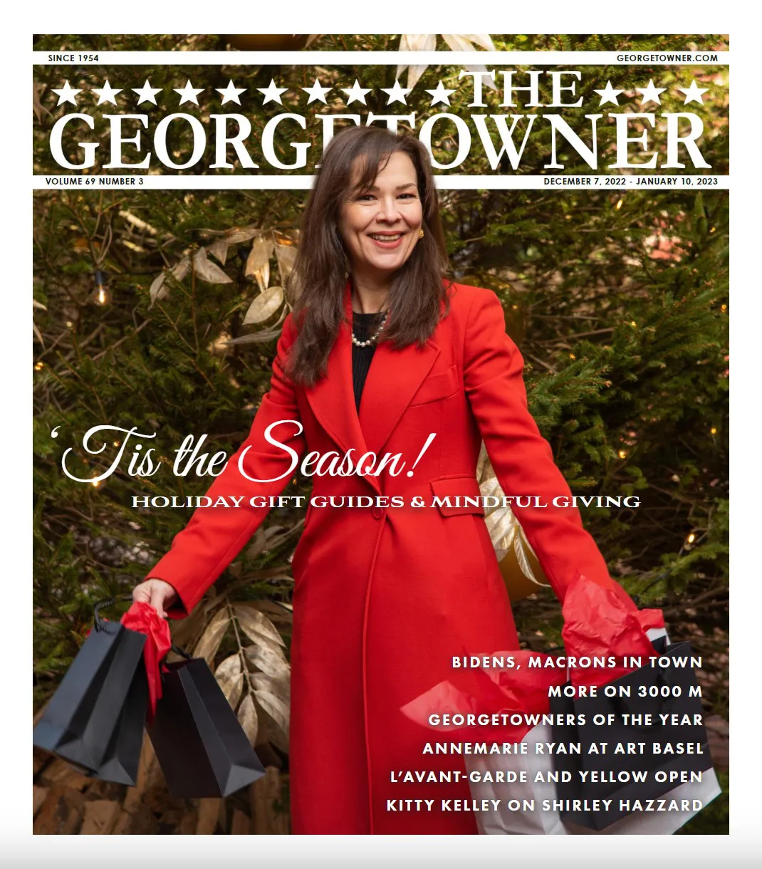 Woman with long brown hair, wearing a long red coat, and smiling holding Christmas gifts on a cover of a magazine