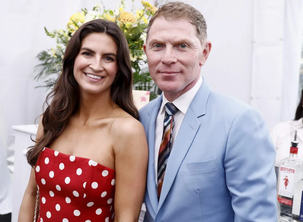 beautiful brunette with long brown hair wearing red polka dot dress standing next to man wearing a light blue suit and red tie