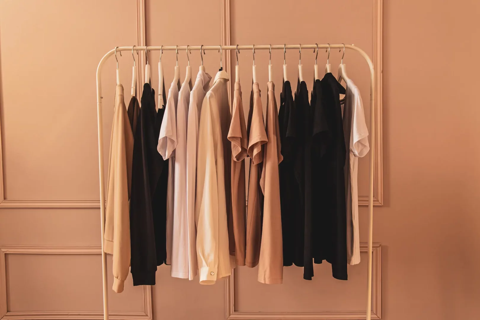 Beige tones women's clothes hanging on clothes rack